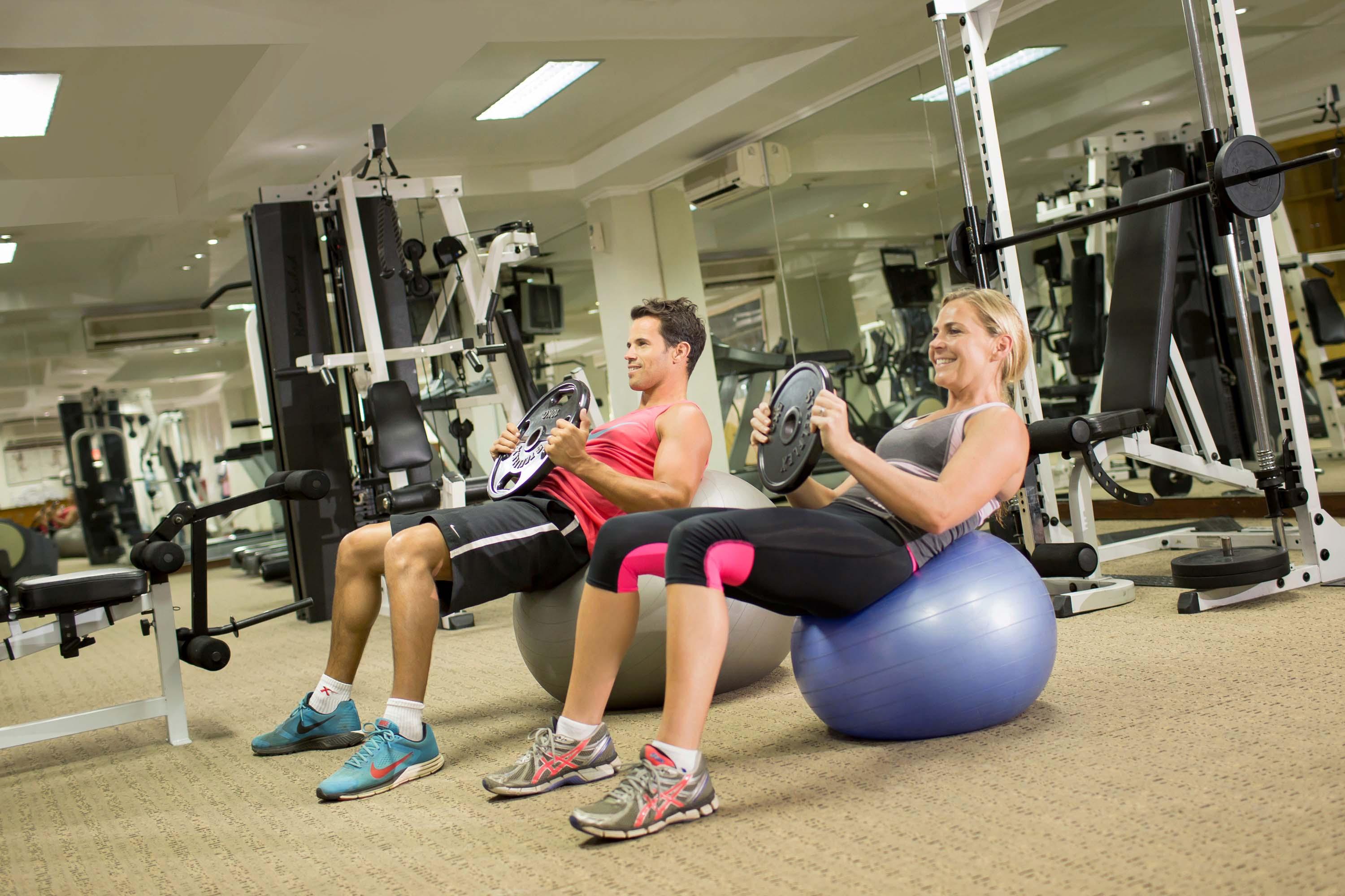 巴厘岛王朝假日酒店 庫塔 外观 照片 A man and woman exercising with a Swiss ball