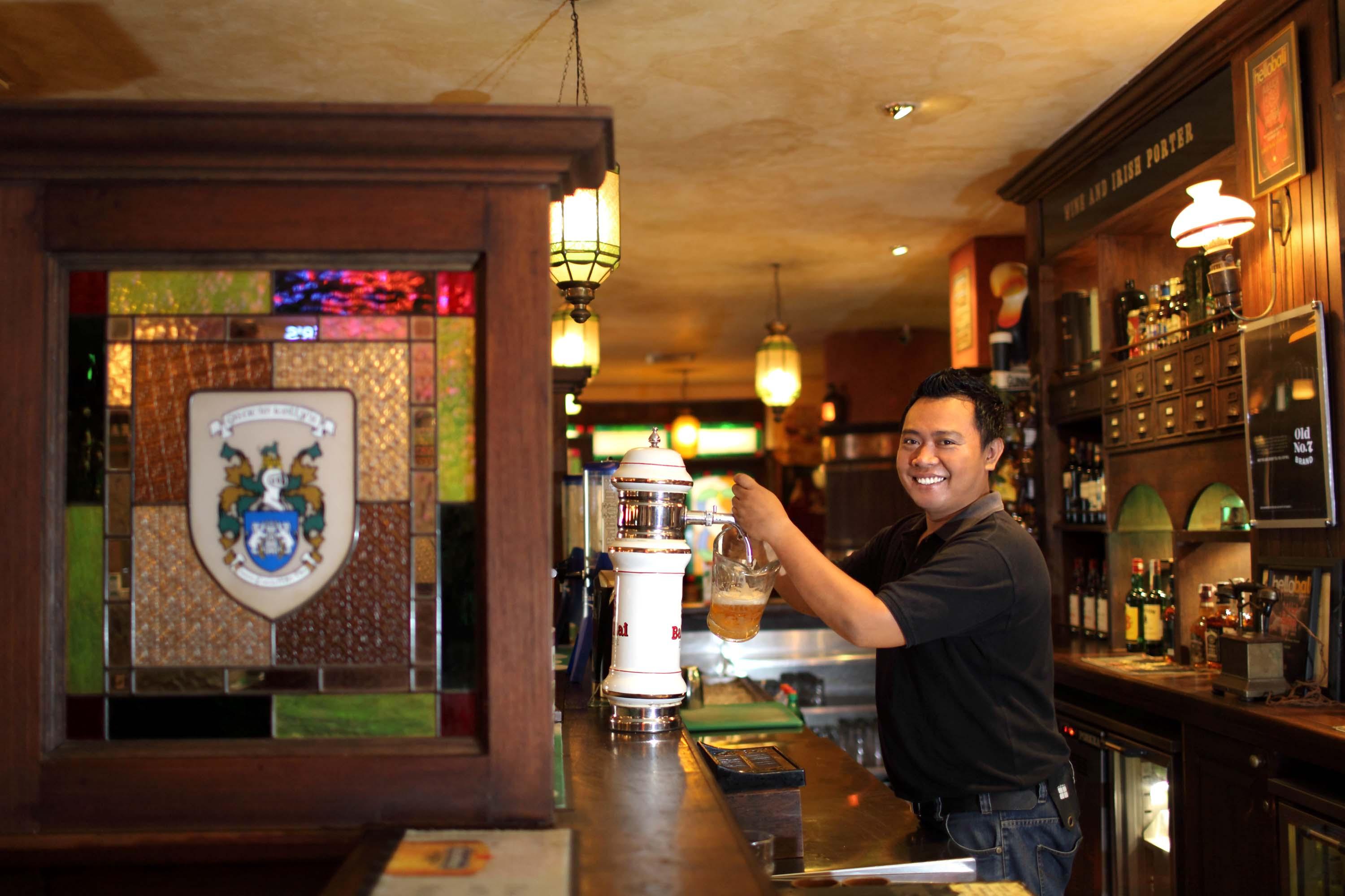 巴厘岛王朝假日酒店 庫塔 外观 照片 A bartender at work