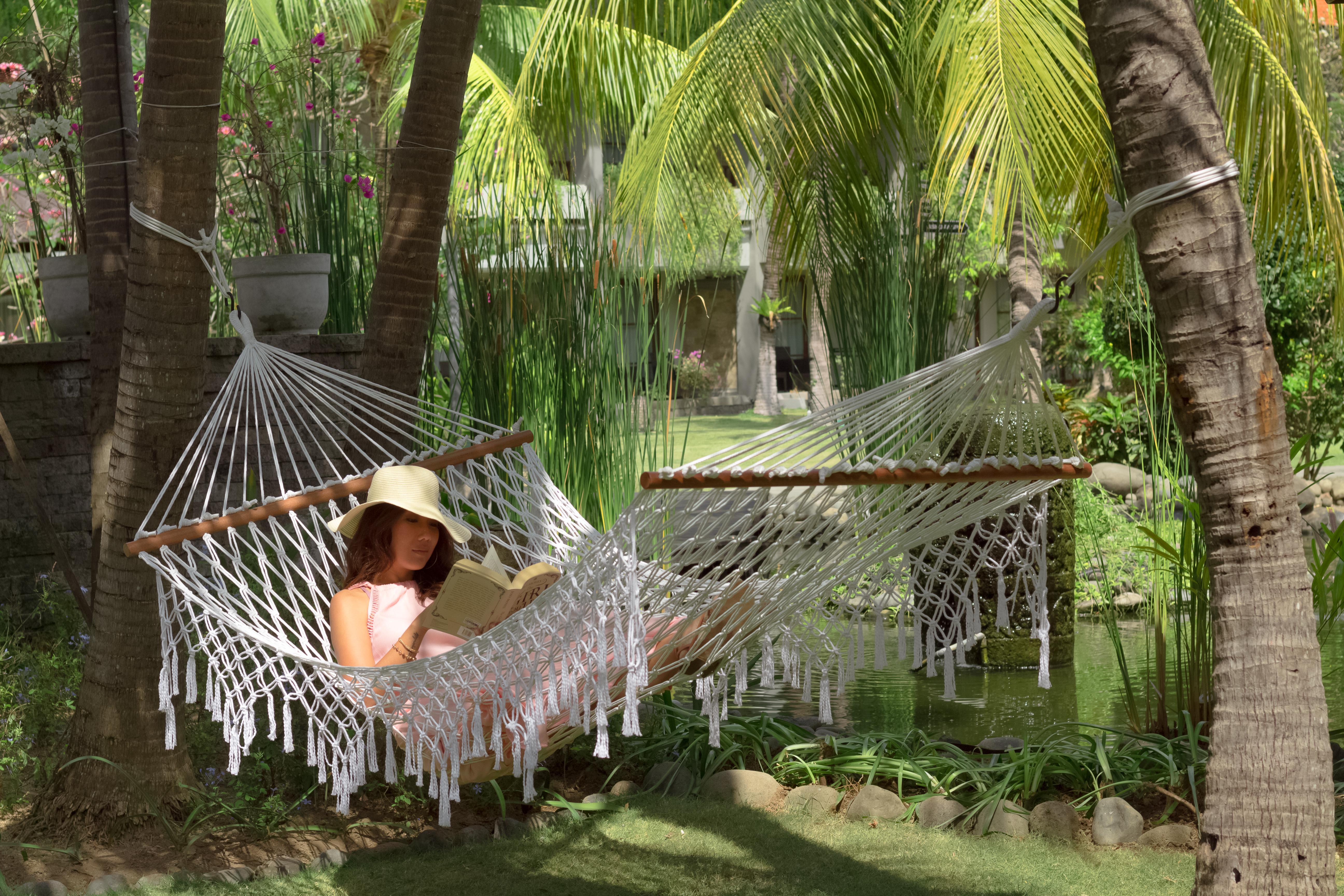 巴厘岛王朝假日酒店 庫塔 外观 照片 A woman relaxing in a hammock